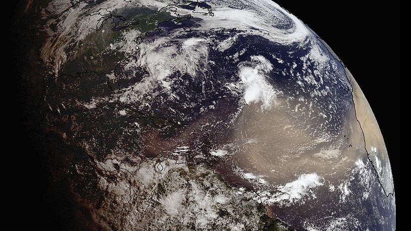 In a photo provided by NOAA, a giant plume of Saharan dust on a 5,000-mile journey is expected to drift across the southeastern United States this week at altitudes between 20,000 and 30,000 feet, bringing enhanced sunrises and potentially suppressing storm formation.