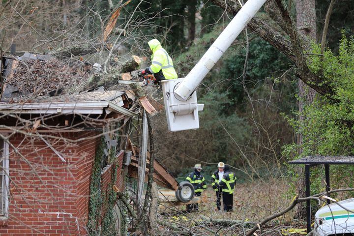 A tree service worker cuts off part of the tree that destroyed a Dekalb County home early Monday as the Dekalb County Fire Department elements investigate the cleaning process. A 5-year-old boy was killed, and his mother was rescued and taken to the hospital.
Monday, January 3, 2022. Miguel Martinez for The Atlanta Journal-Constitution