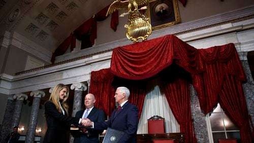 Sen. Kelly Loeffler, R-Ga., left, with her husband Jeffrey Sprecher, center, shakes hands with Vice President Mike Pence after a re-enactment of her swearing-in Monday, Jan. 6, 2020, in the Old Senate Chamber on Capitol Hill in Washington. (AP Photo/Jacquelyn Martin)