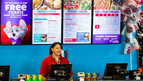 Employee Adrianna Morales stands at the counter in front of a new digital menu board at Chuck E Cheese on Wednesday, April 8, 2015 in Irving, Texas. (Ashley Landis/The Dallas Morning News/TNS)