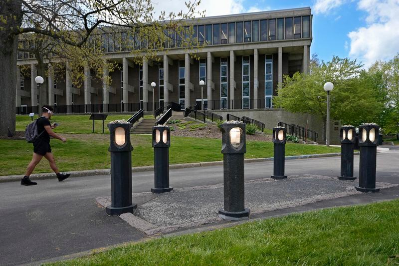 A man walks past the site where student Jeffrey Miller was killed during protests at Kent State University on May 4, 1970, on Wednesday, May 1, 2024, in Kent, Ohio. The four sites where students died are marked off with pillars. (AP Photo/Sue Ogrocki)