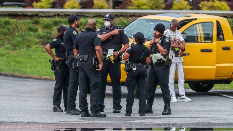 Atlanta police officers investigate a shooting after a gunman tried to steal an armored truck this week. (John Spink / John.Spink@ajc.com)
