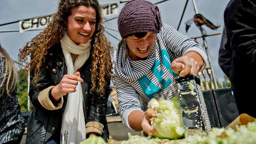 Emma Thibaudeau (left) cheers on Jess Peterick as she shreds cabbage in a competition during the 12th annual Cabbagetown Chomp & Stomp in Atlanta on Saturday, November 1, 2014. The one day festival attracts tens of thousands of people to taste chili, look at art, listen to music and celebrate the historic neighborhood. JONATHAN PHILLIPS / SPECIAL