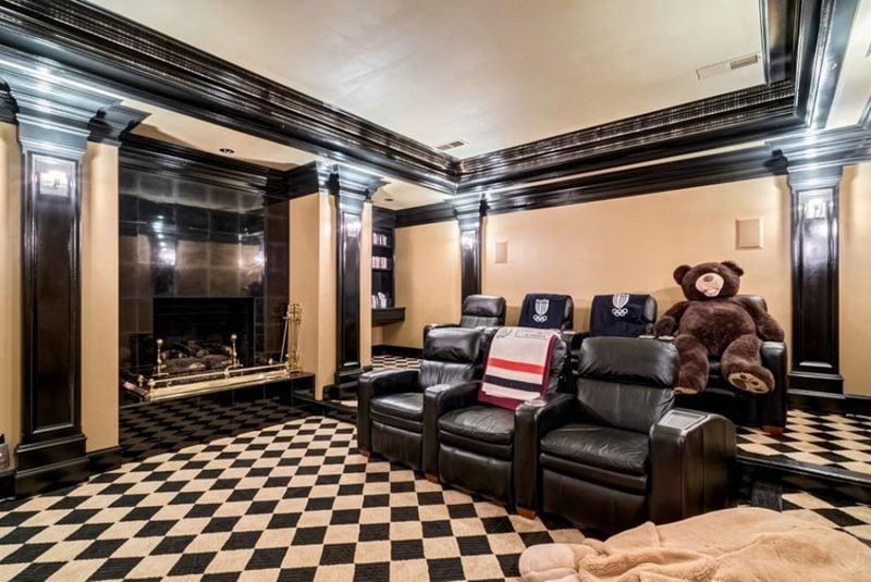 A theater room complete with what looks to be a fireplace.