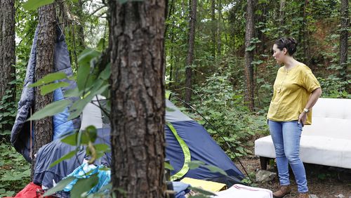Tina Emond, former Director of Coordinated Entry at HomeFirst Gwinnett talks to a woman living in a tent tucked in a wooded area in Norcross on Friday, July 15, 2022.  (Natrice Miller/natrice.miller@ajc.com)
