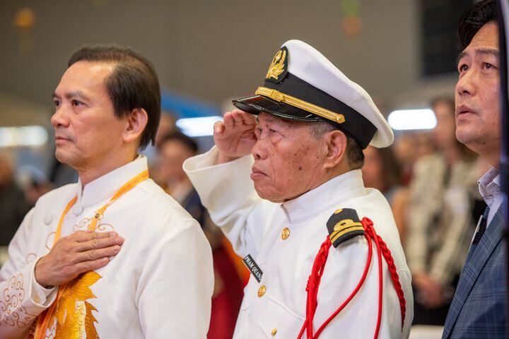 Pham Quano, center, shows respect at the presentation of the flags during a Lunar New Year celebration hosted by The Vietnamese American Community of Georgia at Plaza Las Americas in Lilburn on Saturday, Feb 3, 2024 where dragon and lion dancing begins the weekend.  The celebration continues on Sunday and includes traditional food, music and cultural festivities.  (Jenni Girtman for The Atlanta Journal-Constitution)