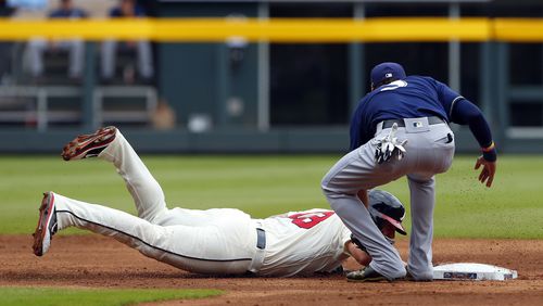 Matt Adams is tagged out by Brewers shortstop Orlando Arcia as he dives back to second base during Sunday&#039;s game at SunTrust Park.