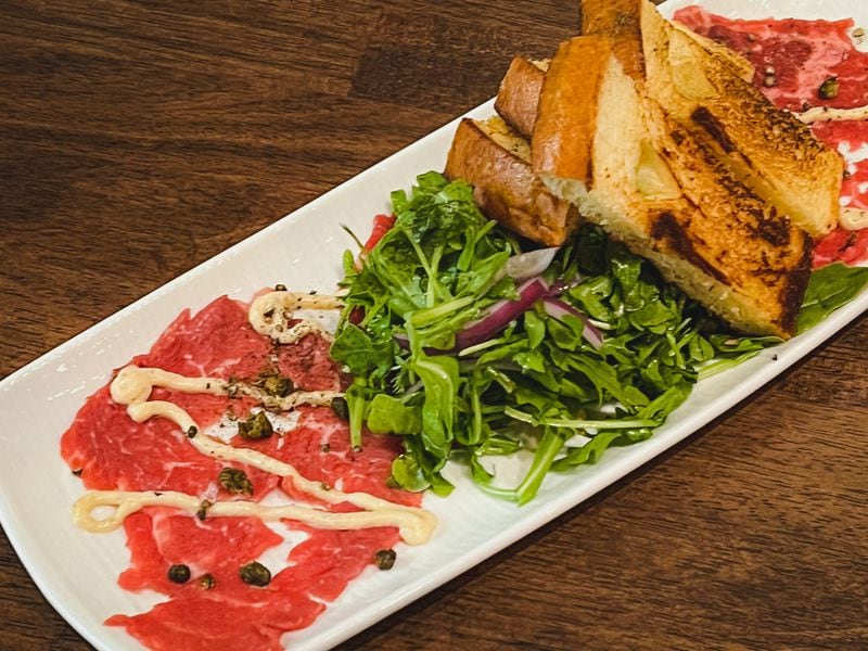 The beef carpaccio at Palm 78 is served with arugula and toast. Henri Hollis/henri.hollis@ajc.com
