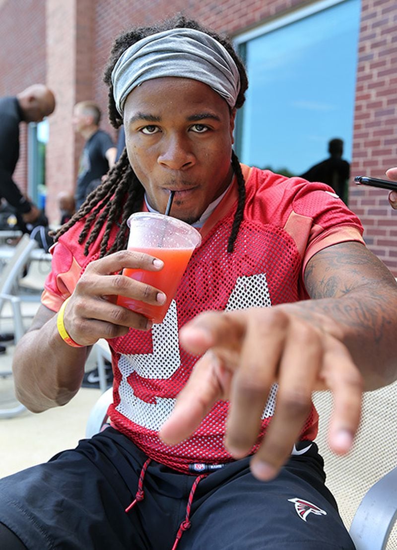 Atlanta Falcons running back Devonta Freeman cools off with a fruit drink after team practice on Tuesday, June 5, 2018, in Flowery Branch.