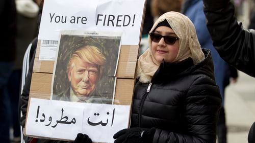 A woman carries a sign outside of the White House during a demonstration to denounce President Donald Trump's executive order that bars citizens of seven predominantly Muslim-majority countries from entering the United States on Sunday, Jan. 29, 2017, in Washington.(AP Photo/Jose Luis Magana)