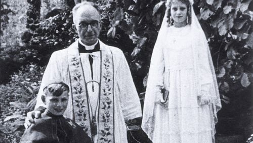 Holocaust survivor Beatrice Muchman, while in hiding, wearing her first communion dress. She is standing next to Father Vaes and her cousin, Henri, a choir boy.