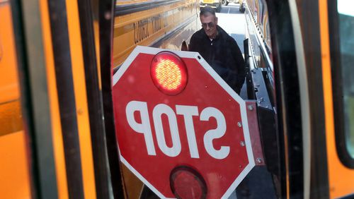 Fleet manager Charles Smith is reflected in a side mirror while going over a detecting system that can warn drivers there is an object near their bus at the Carroll Pitts Jr. Transportation Center in Marietta. Attention to school bus safety has heightened after students were killed in a Chattanooga bus crash. Curtis Compton/ccompton@ajc.com