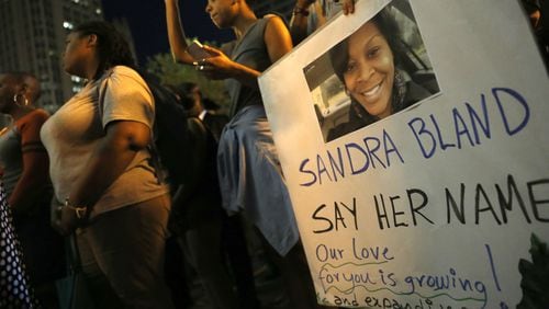 A demonstrator holds a Sandra Bland sign during a candlelight vigil July 28, 2015, near the DuSable Bridge on Michigan Avenue in Chicago. Bland, 28, died of apparent suicide in her jail cell three days after a July 10, 2015, traffic stop near the campus of Prairie View A&M University in Prairie View, Texas, where she attended college and had just gotten a new job.