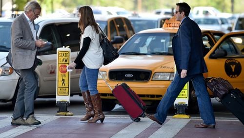 April 22, 2015 Atlanta: These airline passengers were walking to and from an airport shuttle at Hartsfield Jackson International Airport, but some passengers are bypassing traditional transportation such as taxis and shuttles, opting for the growing popularity of social media based ride services such as Uber. BRANT SANDERLIN/BSANDERLIN@AJC.COM