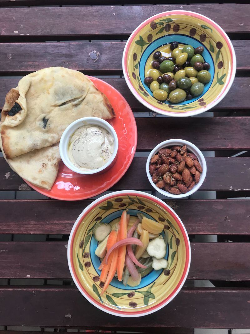 The Mezze Mini from Hazel Jane's is a snack sampler that includes rosemary-roasted almonds, citrus-marinated olives, pickled vegetables, house-made hummus and flatbread. LIGAYA FIGUERAS / LIGAYA.FIGUERAS@AJC.COM