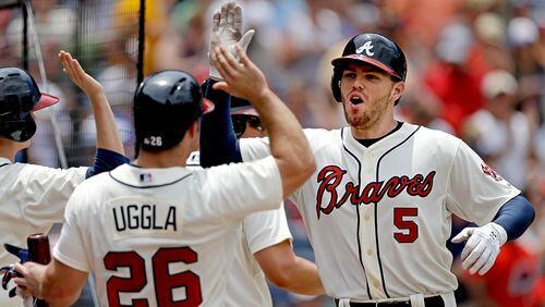 Atlanta Braves' Freddie Freeman, right, is high-fived by teammates after hitting a three-run home run in the third inning.
