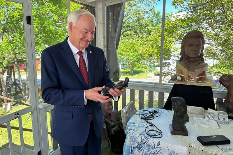 Former Arkansas Gov. Asa Hutchinson holds a small-scale statue of Johnny Cash, on April 23, 2024, in Little Rock, Ark. Artist Kevin Kresse's full sculpture of Cash will be unveiled at the U.S. Capitol as part of the Statuary Hall collection, later this year. (AP Photo/Andrew DeMillo)