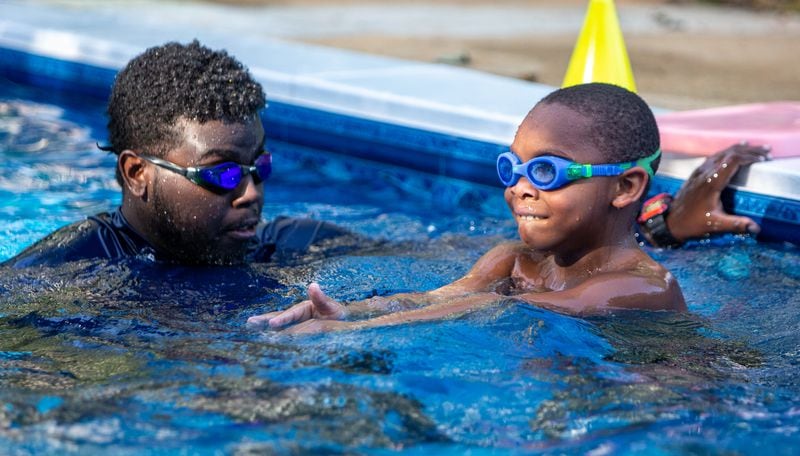 Dunbar Elementary School student Nathan Tomlinson (right, age 7) gets helps from SwemKids instructor Josiah Mwangi (CQ according to organizer). After COVID shuttered pools, a Fayetteville man offered his backyard pool for swimming instruction & water safety lessons to Atlanta city kids. SwemKids is a nonprofit that offers free swimming gear & lessons as an in-school program for kids in low income neighborhoods.  PHIL SKINNER FOR THE ATLANTA JOURNAL-CONSTITUTION.