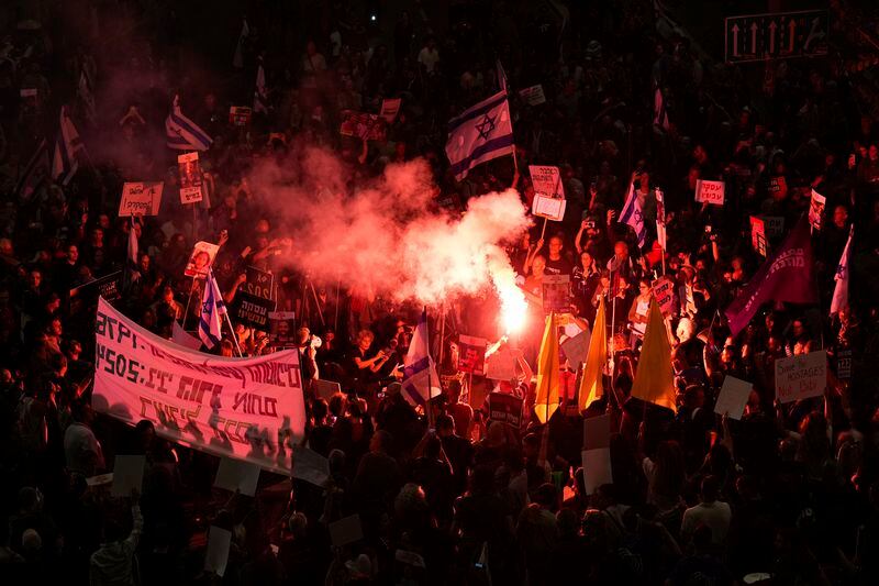 Israeli demonstrators block a road after Hamas's announcement that it has accepted a cease-fire proposal, urging the Israeli government to agree to a deal that would bring home hostages held by the Islamic militant group, in Tel Aviv, Israel, Monday, May 6, 2024. (AP Photo/Ariel Schalit)