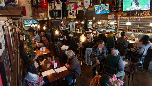 Customers eat and watch college women's lacrosse and beach volleyball matches on big-screen TVs at The Sports Bra sports bar on Wednesday, April 24, 2024, in Portland, Ore. (AP Photo/Jenny Kane)