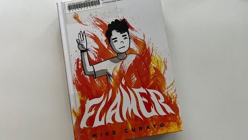 "Flamer" by Mike Curato, a graphic novel set in a 1995 summer camp about a boy who is bullied for appearing gay, has been removed from schools in Cobb County and Marietta for containing "sexually explicit content." This copy was checked out from the Fulton County Library System. (Cassidy Alexander / Cassidy.Alexander@ajc.com)