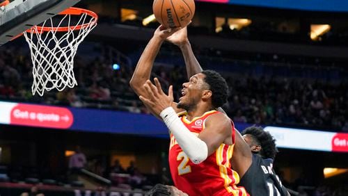 Atlanta Hawks' Trent Forrest (2) goes up for a shot against Orlando Magic's Mo Bamba, right, during the first half of an NBA basketball game, Wednesday, Dec. 14, 2022, in Orlando, Fla. (AP Photo/John Raoux)