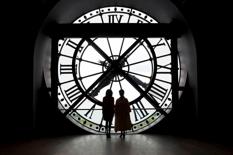 China's President Xi Jinping's wife Peng Liyuan, right, and French President Emmanuel Macron's wife Brigitte Macron pose in front of the clock as they visit the Orsay Museum, Monday, May 6, 2024 in Paris. China's President Xi Jinping is in France for a two-day state visit that is expected to focus both on trade disputes and diplomatic efforts to convince Beijing to use its influence to move Russia toward ending the war in Ukraine. (AP Photo/Aurelien Morissard, Pool)