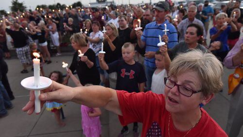 Hundreds gather for a candlelight vigil to honor Brent Thompson, the Dallas Area Rapid Transit officer killed in the Thursday night attack, at Corsicana High School in Corsicana, Texas, on Sunday. Thompson was a Corsicana native and a graduate of Corsicana High. HYOSUB SHIN / HSHIN@AJC.COM