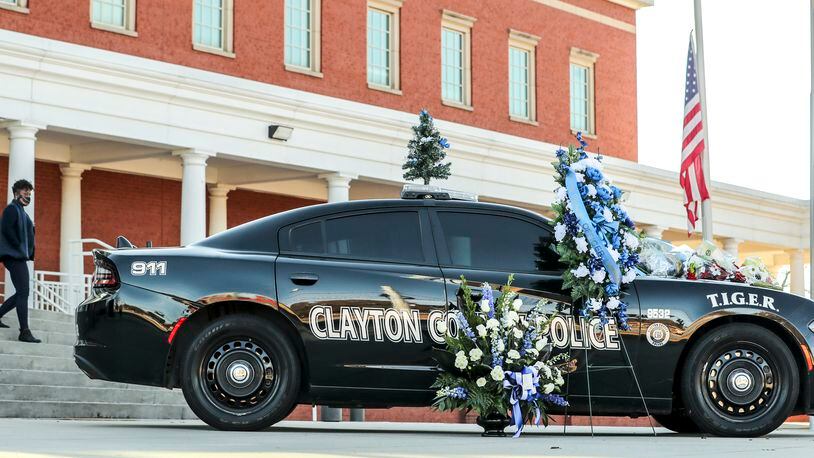 Flowers adorn a Clayton County police vehicle in December after the death of Henry Laxson, a Clayton field training officer killed in the line of duty. (John Spink / John.Spink@ajc.com)