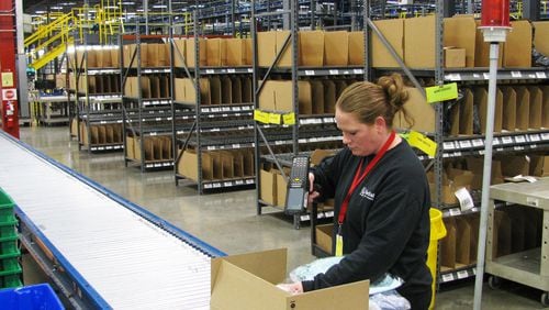 Worker packing goods to be shipped from Radial's Locust Grove distribution center. The facility is part of Radial's network of centers. The Belgian-owned company is ramping up for the seasonal rush.