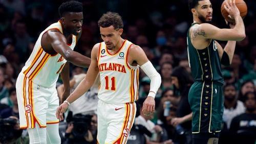 Atlanta Hawks' Clint Capela, left, reaches out to Trae Young (11) beside Boston Celtics' Jayson Tatum, right, in the second half during Game 1 in the first round of the NBA basketball playoffs, Saturday, April 15, 2023, in Boston. (AP Photo/Michael Dwyer)