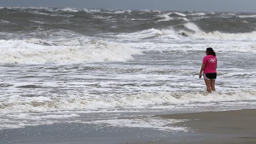 A woman takes in the surf in September before Hurricane Irma arrives at Tybee Island. The beaches on Tybee, Jekyll and St. Simons islands suffered heavy damage when Hurricanes Irma and Matthew battered them. Curtis Compton/ccompton@ajc.com