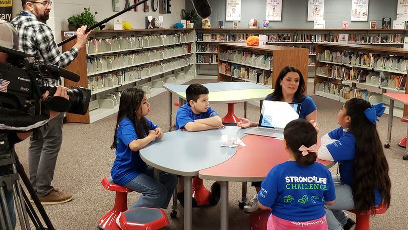 Meteorologist Milmar Ramirez and Hopkins Elementary students discuss the weather for a Spanish-language segment aimed at young viewers.