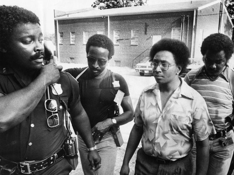 Police officers escort Wayne Williams, center, back to his house after he had an impromptu talk with the press on June 6, 1981. Williams was ultimately convicted as the lone killer in the Atlanta Child Murders, a law enforcement conclusion that remains controversial. 