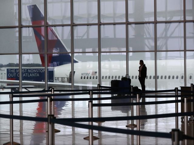 March 16, 2020 Atlanta: A Delta plane sits at the International Terminal at Hartsfield Jackson International Airport with a solitary traveler waiting for a flight amid new European travel restrictions on Monday, March 16, 2020, in Atlanta. International and domestic air travel have been hammered by the coronavirus.   Curtis Compton ccompton@ajc.com