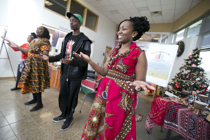 Carol Kariuki, far right, joins, from left, Theresa Garcia, Elizabeth Kahura and Andrew Kahura, 14, as they encourage the audience dance along with them during a Kwanzaa Celebration at the George Washington Carver Museum on Friday, December 26, 2014. The event was celebrating the first day of Kwanzaa which focuses on Unity (Umoja). DEBORAH CANNON / AMERICAN-STATESMAN