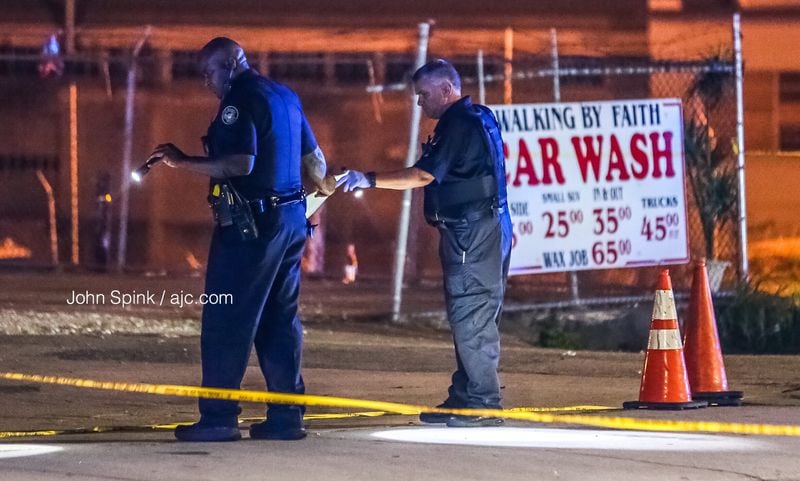 Officers search for evidence after two groups started shooting in the middle of Donald Lee Hollowell Parkway on Sept. 3.