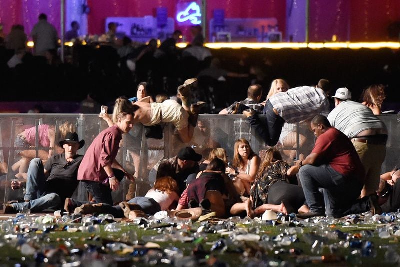 LAS VEGAS, NV - OCTOBER 01:  People scramble for shelter at the Route 91 Harvest country music festival after apparent gun fire was heard on October 1, 2017 in Las Vegas, Nevada. A gunman  opened fire on a music festival in Las Vegas, leaving at least 20 people dead and more than 100 injured. Police have confirmed that one suspect has been shot. The investigation is ongoing. (Photo by David Becker/Getty Images)
