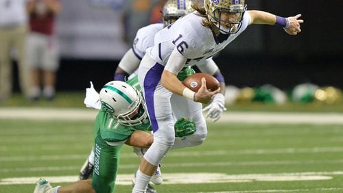 Cartersville Trevor Lawrence (16) gets tackled by Buford Jake Simpson (17) during Cartersville's 10-0 win over Buford in the GHSA Class AAAA State Championship at the Georgia Dome on Saturday December 12, 2015. HYOSUB SHIN / HSHIN@AJC.COM