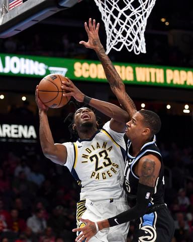 Indiana Pacers forward Aaron Nesmith (23) drives to the basket against Atlanta Hawks guard Dejounte Murray (5) during the first half of an NBA game Tuesday, November 21, 2023. (Daniel Varnado/For the AJC)