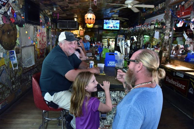 September 3, 2019 Tybee Island - John Potter, left, a longtime Tybee Island resident, plans to remain on the island during the storm to help his friends, who own the Huc-a-Poo’s Bites and Booze restaurant. (Hyosub Shin / Hyosub.Shin@ajc.com)