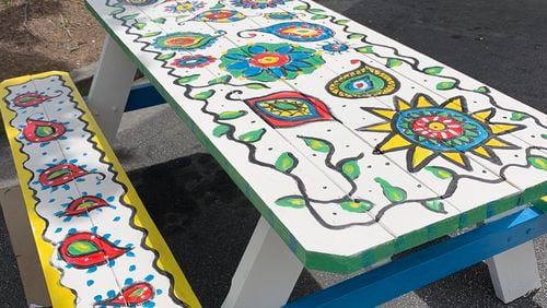 Dunwoody’s Economic Development Department is connecting local restaurants with community groups to add a creative touch to outdoor dining. This picnic table was painted by the Dunwoody Fine Art Association for Vino Venue. CONTRIBUTED