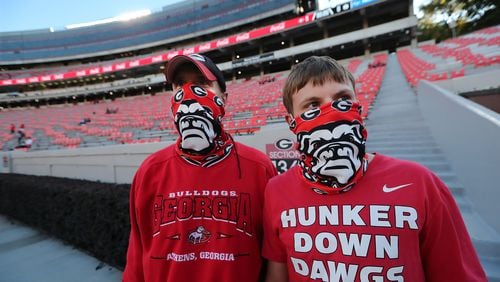 100320 Athens: Georgia fans Rod Carnes (left) and his son Colin mask up as they arrive in Sanford Stadium to watch their team take on Auburn in a SEC college football game on Saturday, Oct 3, 2020 in Athens.   “Curtis Compton / Curtis.Compton@ajc.com”