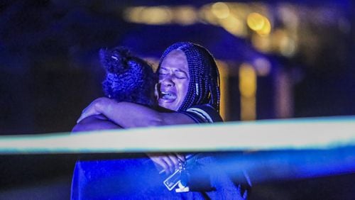 Friends and family members of a man who was shot and killed early Thursday, Feb. 22, 2018, in DeKalb County grieve at the scene. Nicholas Bankston was returning home following his own birthday celebration when he was shot and killed, according to neighbors. His children and two other adults were also in the car, but none were injured. (JOHN SPINK/JSPINK@AJC.COM)