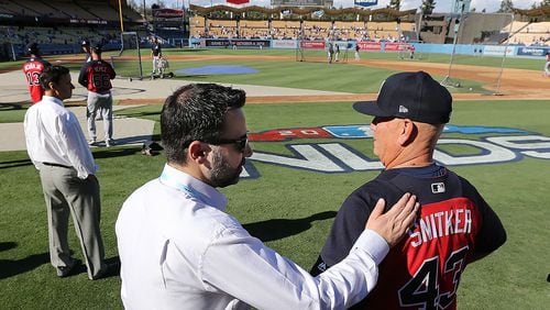 Atlanta Braves general manager Alex Anthopoulos gives manager Brian Snitker a pat on the back before Game 1 of the National League Division Series on Thursday, Oct 4, 2018, in Los Angeles.