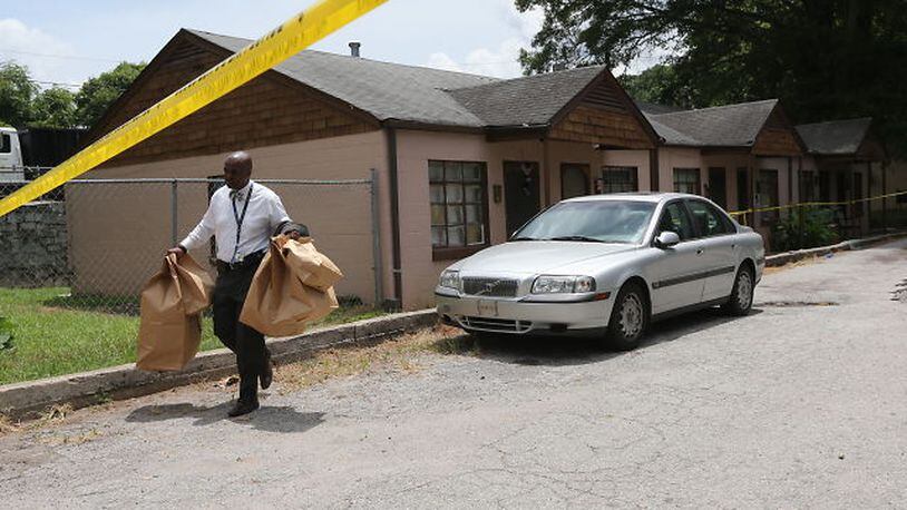 Homicide investigators collect evidence at the scene of shooting involving a 4-year-old boy on Tuesday, July 14, 2015. BEN GRAY / BGRAY@AJC.COM