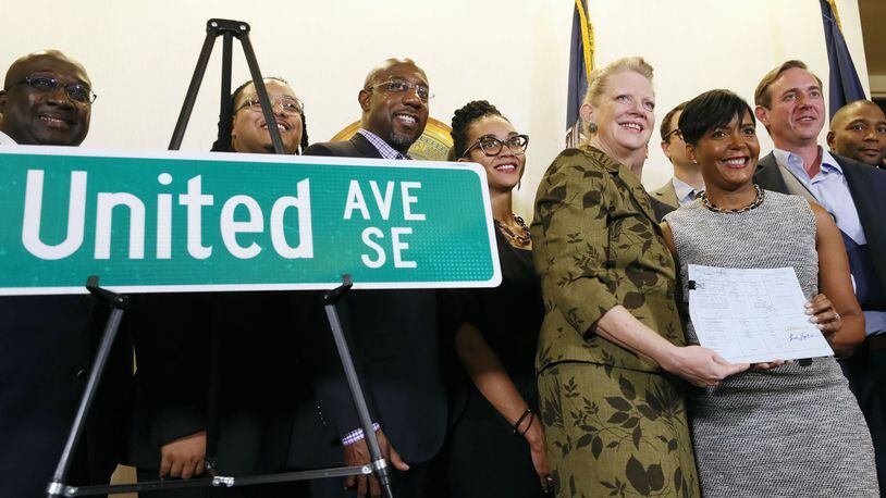 Carla Smith, District 1 council member, and residents of District 1 join together in a commemorative photo after Mayor Keisha Lance Bottoms signed a bill officially changing the name of Confederate Avenue to United Avenue. BOB ANDRES / BANDRES@AJC.COM