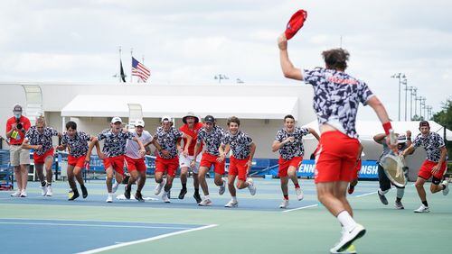Billy Rowe of the University of Georgia celebrates his match-clinching win over North Carolina at No. 5 singles as his teammates rush the court to embrace him at the USTA National Tennis facility in Lake Nona, Fla., on Monday, May 17, 2021(Manuela Davies/USTA)