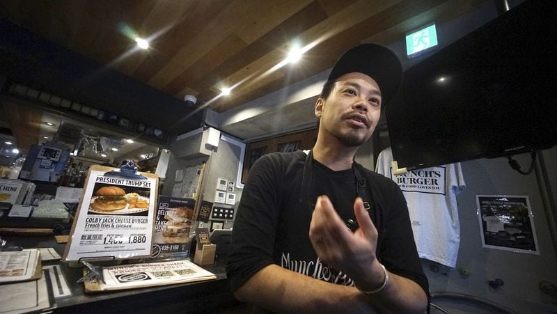 Yutaka Yanagisawa, owner of Munch's Burger Shack restaurant, speaks during an interview with The Associated Press in Tokyo Thursday, Nov. 16, 2017. The cheeseburger U.S. President Donald Trump had during his recent visit to Japan is still drawing lines at the Tokyo burger joint. (AP Photo/Eugene Hoshiko)