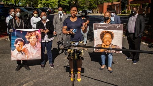 Tilafayea Walker speaks at a press conference in April while other family members of Nancy Finney hold up photographs. Finney, 73, died of COVID-19 while living at the Arbor Terrace at Cascade senior care facility in Fulton County. (Steve Schaefer / Special to the AJC)